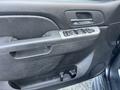 Interior door panel of a 2011 Chevrolet Avalanche featuring control buttons for windows and door handles along with a black textured surface