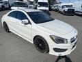 A white 2014 Mercedes-Benz CLA-Class with black alloy wheels and a sleek design parked with other vehicles in the background
