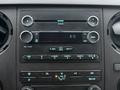 Dashboard control panel of a 2015 Ford F-450 featuring audio controls buttons and climate settings with a digital clock display