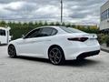 A 2023 Alfa Romeo Giulia in white with distinctive black alloy wheels and sporty design features parked at an angle