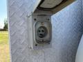 A close-up of a weathered electrical outlet mounted on a metallic surface with a diamond pattern