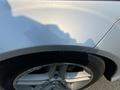 A silver 2013 Mercedes-Benz C-Class with a close-up view of its wheel and fender showcasing sleek lines and design features