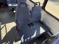 A pair of blue fabric seats with seat belts installed in a spacious vehicle interior