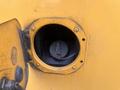 Close-up of a fuel cap inside a circular opening on a yellow 2007 Freightliner B2 vehicle