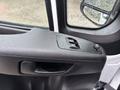 Interior door panel of a 2023 RAM Promaster 3500 featuring controls for windows and door handle with water droplets visible on the surface