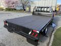 A black 2020 Ford F-550 pickup truck with a flatbed and wood flooring in the truck bed
