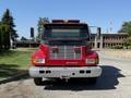 Front view of a red 1991 International 4600 truck with a chrome grill and emergency lights on the roof showcasing a sign that reads WE SUPPORT OUR CANADIAN FORCES