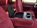 The interior of a 1995 Ford F-250 featuring red upholstered seats and a central armrest with cup holders and a storage compartment