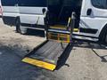 A wheelchair ramp is extended from the rear of a 2020 RAM ProMaster 3500, featuring a metal mesh surface and yellow safety edges.