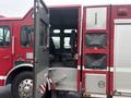 A red 2006 E-One Typhoon fire truck with an open door revealing a spacious interior featuring several seats for firefighters