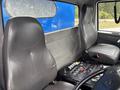 Interior of a 2013 International DuraStar 4300 with two leather seats and a control panel featuring various buttons and knobs