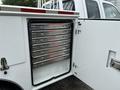 A white 2013 Ford F-250 SD with a service body featuring an open compartment displaying multiple metal tool drawers