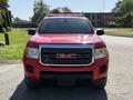 A red 2018 GMC Canyon is parked facing the camera showcasing its prominent grille and headlights