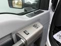 Close-up of the interior door controls of a 2012 Ford F-550 featuring window and lock buttons in a gray panel