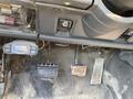 Interior view of a 1996 GMC Top Kick showing the pedals and control switches with worn and dusty surfaces