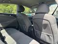 Interior view of a 2014 Hyundai Sonata showing the back seats and headrests with a light gray fabric upholstery