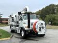 A white 2006 Sterling L7500 truck with large hoses and equipment mounted on the back for vacuuming or debris collection