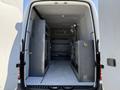 The interior of a 2017 Mercedes-Benz Sprinter van showing metal storage shelves on both sides and a clear floor space in the center