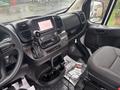 Interior view of a 2023 RAM Promaster 3500 showing the dashboard with a touchscreen display gear shift and seating area