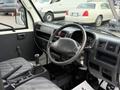 Interior view of a 2009 Suzuki Carry featuring a steering wheel gear stick and dashboard controls in a gray and black color scheme
