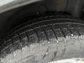 A close-up of a tire from a 2016 Subaru Forester showcasing deep treads and a slightly wet surface