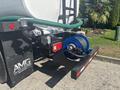 2022 Freightliner M2 106 with a reel and hose connected to a tank equipped with a black and red bumper featuring lights and a logo on the side