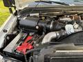A 2010 Ford F-550 engine compartment featuring a black air filter housing battery and various hoses and components visible