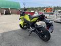 A bright yellow 2018 Honda Grom motorcycle viewed from the rear with a sporty design and a compact frame