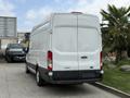 A white 2017 Ford Transit van parked with its rear facing the viewer displaying a simple design and large cargo space