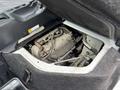 A 2010 Suzuki Carry with its hood raised exposing the engine compartment and engine components in view