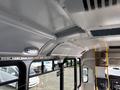 Interior of a 2018 Chevrolet Express bus featuring overhead lights a smooth ceiling and a driver seat with controls visible