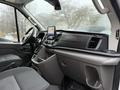 Interior of a 2020 Ford Transit featuring a touchscreen display dashboard and spacious seating area with a central console