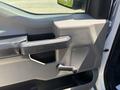 Close-up of the door panel of a 2019 Ford F-150 featuring a handle a speaker and a manual window crank
