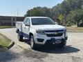 A white 2017 Chevrolet Colorado pickup truck with a blue bed and a front-mounted winch
