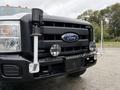 A 2015 Ford F-350 SD with a black front grille featuring the Ford logo and mounted spotlights on either side of the grille