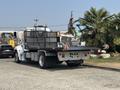 A white 2020 Peterbilt 330 flatbed truck with a black bed and visible marker lights on top
