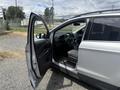 A 2015 Ford Escape with the driver's side door open showcasing the interior features and seats