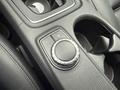 A close-up of the control dial and buttons on the center console of a 2016 Mercedes-Benz GLA-250