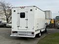 A white 2012 Ford F-550 truck with a boxy cargo area and a single rear door