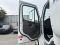 A 2006 Freightliner M2 106 truck with its driver's side door open revealing the interior and driver seat area