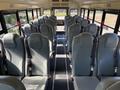 The interior of a 2013 International CE300 school bus with gray seats arranged in rows and safety belts attached to each seat