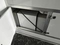 A storage compartment within a 2020 Freightliner MT45 showcasing a white box secured with black straps and access from a white door