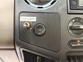 A close-up view of the dashboard controls in a 2010 Ford F-550 featuring a fog lights switch a traction control button and various climate control knobs