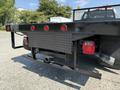 A 2018 Ford F-550 with a sturdy flatbed and equipped with trailer hitch and red tail lights