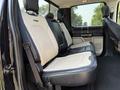 Interior view of a 2021 Ford F-350 SD featuring leather-trimmed rear seats in black and cream with a spacious seating arrangement