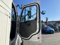 A 2006 Freightliner M2 106 truck door is open showcasing the interior design and control layout of the cabin