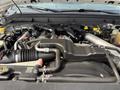 A 2011 Ford F-350 SD engine with various components including hoses wiring and a large air intake system visible in the foreground