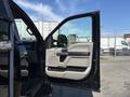 A 2022 Ford F-350 SD with an open driver's door showing the interior door panel and upholstery