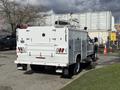 A 2024 Ford F-550 with a white utility body equipped with compartments and equipment mounted on the bed