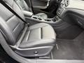 Interior view of a 2016 Mercedes-Benz GLA-250 showing the driver's seat with black leather upholstery and a seatbelt fastened
